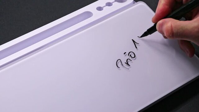 European male hand writing Prio 1 on whiteboard with black pen and erases it with white sponge afterwards for seamless looping message writing on whiteboard. High priority task urgency.