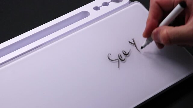 European male hand writing see you on whiteboard with black pen and erases it with white sponge afterwards for seamless looping message writing on whiteboard. Good bye text see you soon.