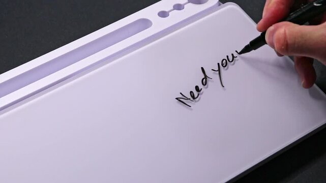 European male hand writing need your support on whiteboard with black pen and erases it with white sponge afterwards for seamless looping message writing on whiteboard. Help needed support text.