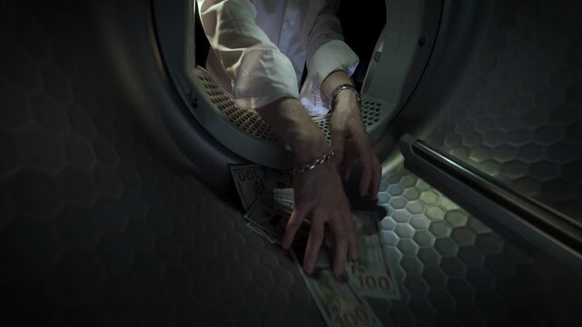 Conceptual video of a Caucasian man wearing a white shirt placing US dollar banknotes in a washing machine with his hands and taking them out in slow motion. Money laundering.