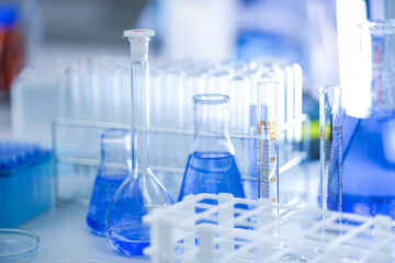 A research microscope and rows of laboratory glassware arranged inside a university biotechnology...