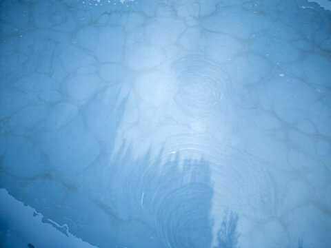 Aerial view of frozen pond surface with trapped air bubbles and tree reflections in Parco Nazionale dell'Appennino Tosco-Emiliano, Sassalbo, Massa-Carrara, Italy.