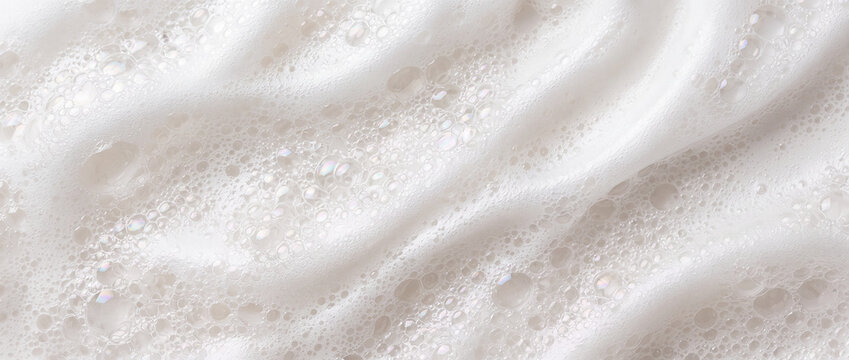 White foam texture with soap bubbles arranged in soft wavy ripples, capturing airy macro details and smooth lather for cosmetic skincare, facial cleanser, or beauty product packaging background