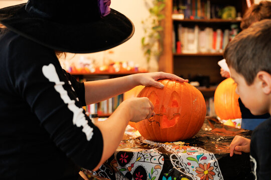Woman and child carving a pumpkin for Halloween