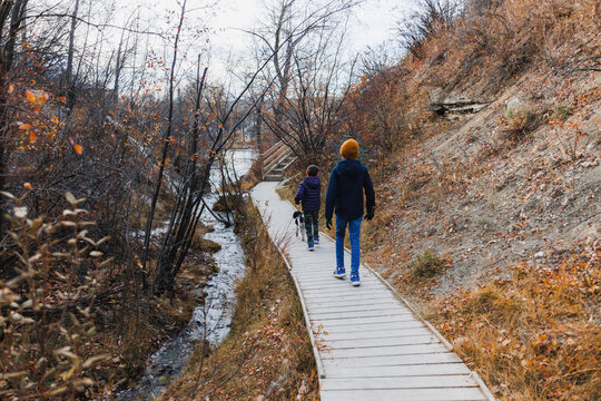 Two young boys walking along a wooden platform at a park in Autumn