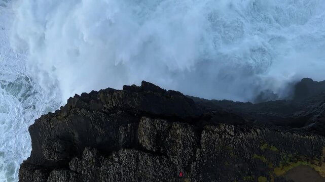 Top-down aerial view of rough Atlantic waves breaking on rocky coast at Kilkee Cliffs along the Wild Atlantic Way