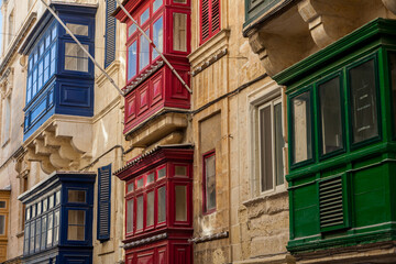 Blue, red, and green gallarija balconies line a limestone facade in a classic display of Valletta's traditional colours © Tony Blood