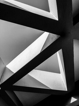 A high contrast black and white fine art photograph showcasing minimalist geometric lines, triangles, and intersecting concrete structural shapes.