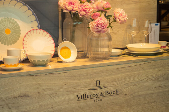 Wolfsburg, Germany - 10 August 2026: Decorative porcelain plates, cups, and artificial peony flowers displayed at a Villeroy Boch store in Wolfsburg
