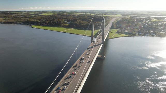 Aerial footage of the New Little Belt suspension bridge crossing calm blue water between Jutland and Funen near Middelfart and Fredericia, Denmark.