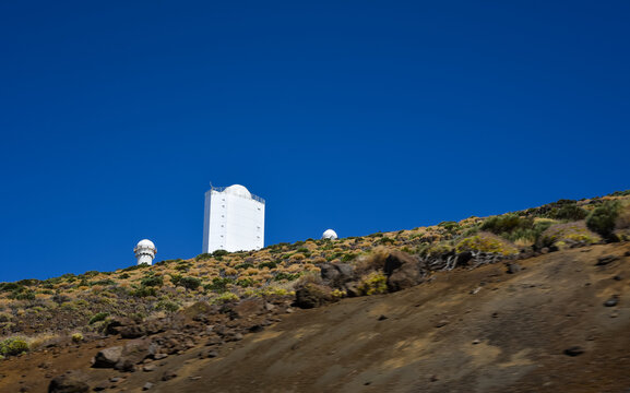 Minimalist view of Teide Observatory dome on a volcanic ridge against vast deep blue sky with large copy space, ideal for banners and travel posters, Tenerife, Canary Islands, Spain