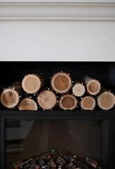 Naklejka premium Cozy home interior design with stacked firewood logs in a modern fireplace, natural wood texture and warmth