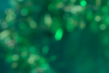 Vibrant green christmas bokeh lights form a serene and peaceful festive background full of natural glow. © Sandra