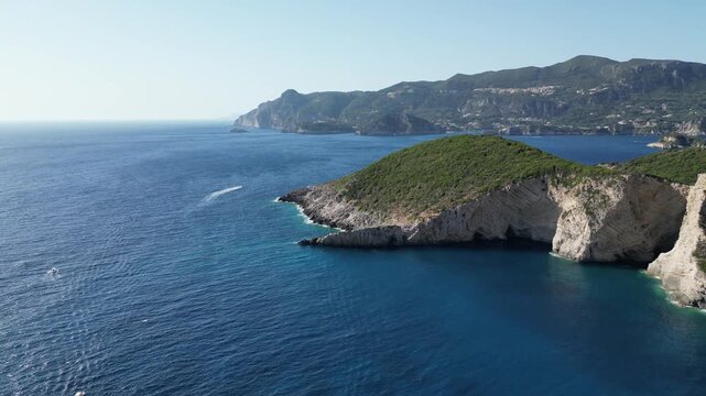 4K Aerial high‑angle 180‑degree panorama shot over Chomi Beach with turquoise water and white cliffs near Paleokastritsa, Corfu, Greece