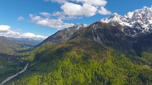 Aerial view of Triglav mountain peak overlooking the lush green forests and valley in the Julian Alps near Mojstrana, Jesenice, Slovenia.