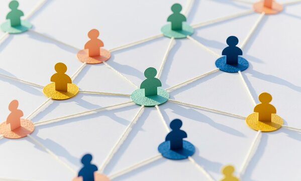 Colorful paper figures connected by threads in a social network concept