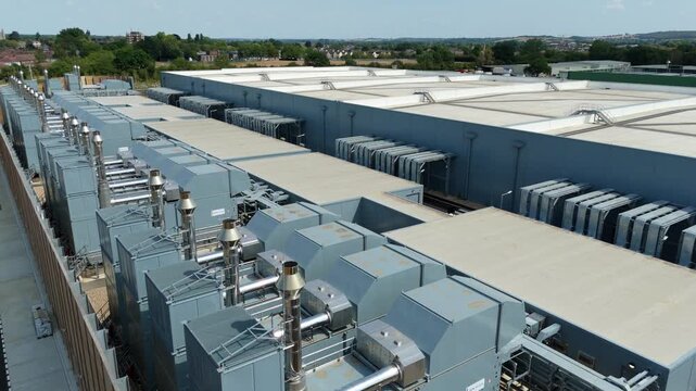 Aerial view of a hyperscale data center featuring rows of external cooling units and server room chillers on the roof in Waltham Cross, England, United Kingdom.