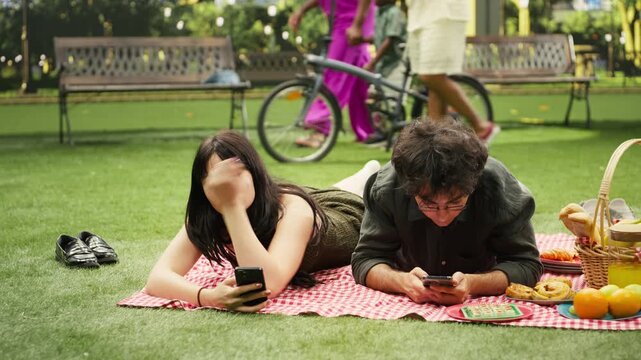 Young couple show phubbing and phone addiction during picnic
