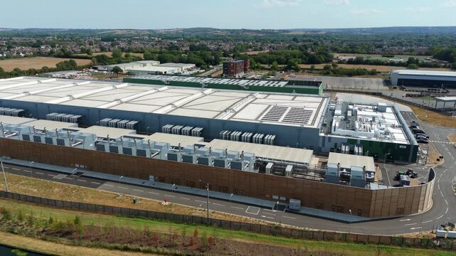 Aerial view of hyperscale data center featuring rows of external cooling units and server room chillers in Waltham Cross, England, United Kingdom.