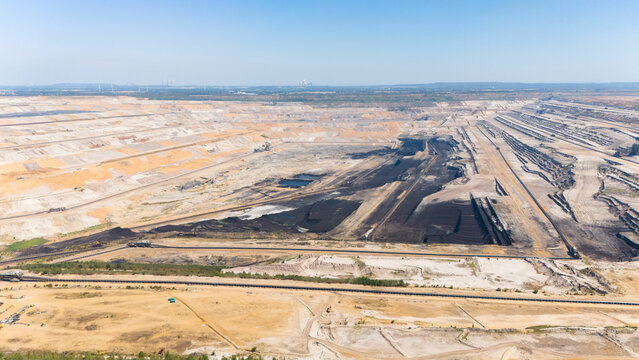 Aerial view of the Hambach open pit mine showing extensive lignite coal mining operations with deep excavation terraces and dark coal seams in Elsdorf, North Rhine-Westphalia, Germany.