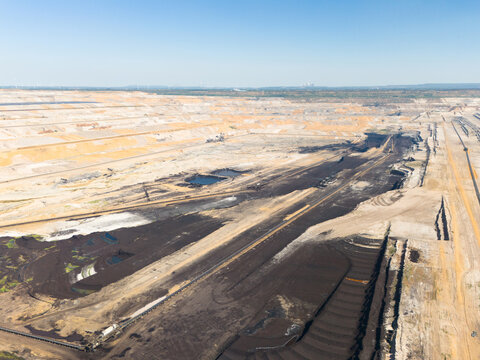 Aerial view of the Hambach open pit mine showing large-scale lignite coal excavation, industrial mining equipment, and vast terraced landscape in Elsdorf, North Rhine-Westphalia, Germany.
