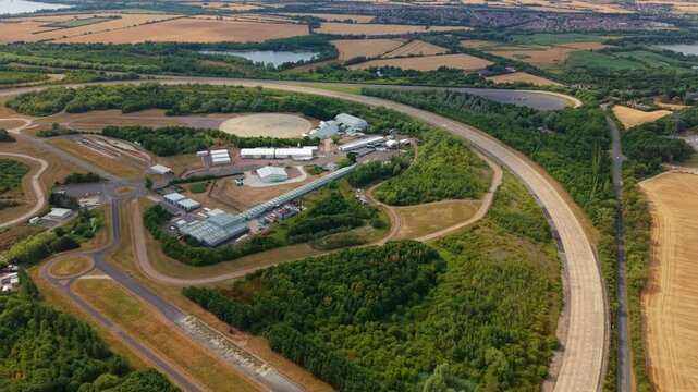 Aerial view of Millbrook Proving Ground with test tracks and facilities surrounded by lush greenery in Bedford, England, United Kingdom.