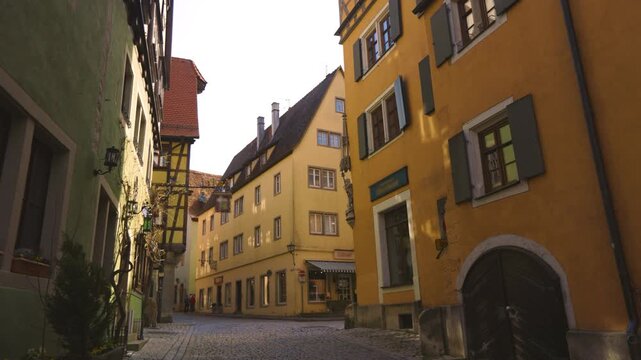 4K footage of a picturesque cobblestone street in Rothenburg ob der Tauber, Germany, surrounded by colorful historic buildings and traditional medieval architecture.