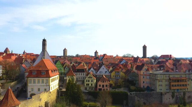4K panoramic view of Rothenburg ob der Tauber, Germany, featuring colorful historic houses, red tiled roofs, medieval towers and the preserved old town skyline.