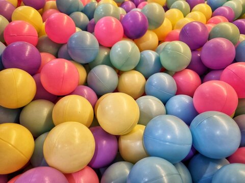 A vibrant ball pit filled with countless colorful plastic balls, makes for a fun filled play area for children