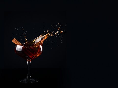Autumn Cocktail Splash with Cinnamon on Black Background
