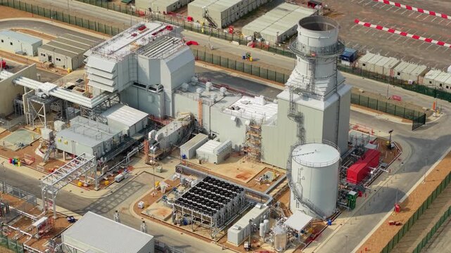 Aerial view of Millbrook Power Plant featuring industrial infrastructure, cooling towers, and storage tanks in Stewartby, England, United Kingdom.