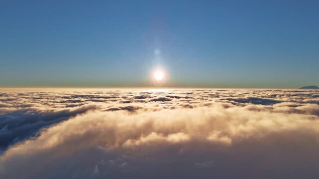 Aerial view of the sunrise over a sea of clouds from Mount Telomoyo via Dalangan in Kecamatan Ngablak, Jawa Tengah, Indonesia.
