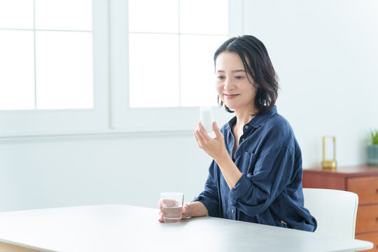 サプリメントをパッケージを確認する中高年女性