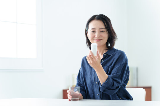 サプリメントをパッケージを確認する中高年女性