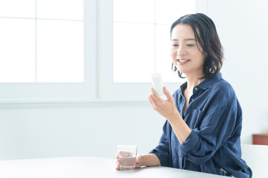 サプリメントをパッケージを確認する中高年女性