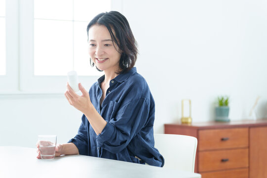 サプリメントをパッケージを確認する中高年女性