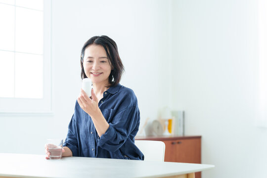 サプリメントをパッケージを確認する中高年女性