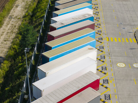 Aerial view of colorful semi-trailers parked in rows at an e-commerce logistics terminal in Poland.