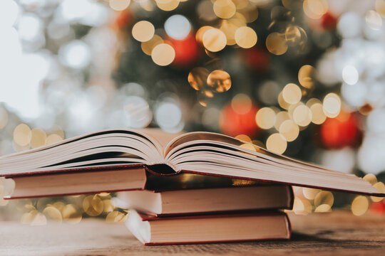 Christmas reading. Book Stack With Christmas Bokeh Background.festive literary background for bookstore advertising, library events, winter reading challenges and holiday storytelling.