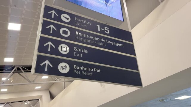 Directional signage inside Vitória Airport indicating gates, baggage claim, exit and pet relief facilities
