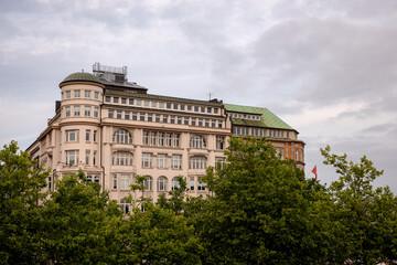 Obraz premium Hamburg, Germany - July 1, 2026: Historic architecture partly obscured by trees in central Hamburg, Germany.