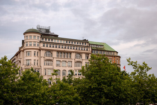 Hamburg, Germany - July 1, 2026: Historic architecture partly obscured by trees in central Hamburg, Germany.