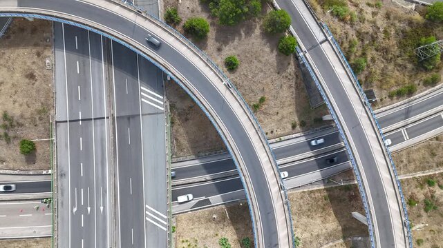 Aerial view of A5 highway interchange with cars driving on curved roads and lanes in Cascais, Lisboa, Portugal.