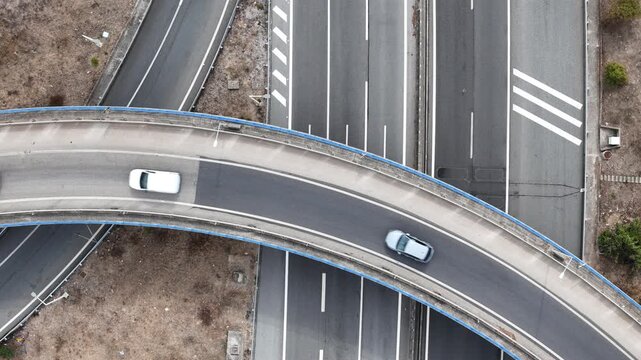 Aerial view of a white bus and car driving on the curved A5 highway overpass in Cascais, Lisboa, Portugal.