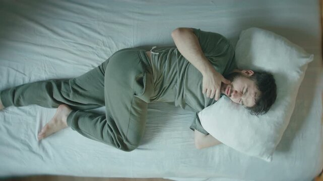 Man Waking Up in Panic Heart Palpitations Anxiety Attack Overhead Bed Sleep