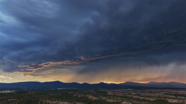 Aerial view of a dramatic monsoon storm forming over the desert landscape during sunset in Los Alamos, NM, United States.