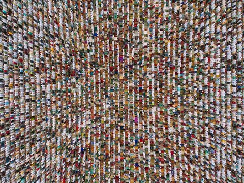 Aerial view of a large crowd of people performing Eid prayer in organized rows on prayer mats in Narayanganj, Dhaka, Bangladesh.