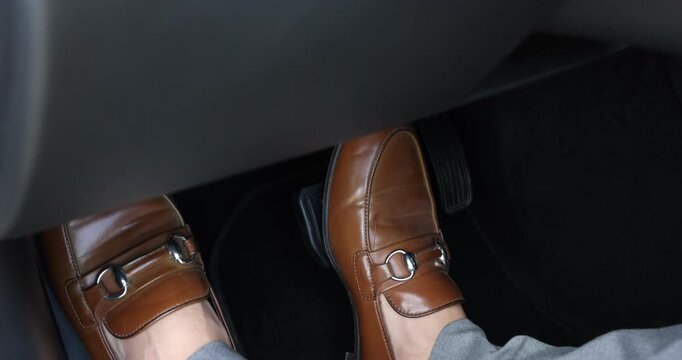 Woman pushing brake pedal in car, closeup on foot