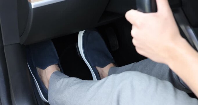 Woman pushing brake pedal in car, closeup on foot