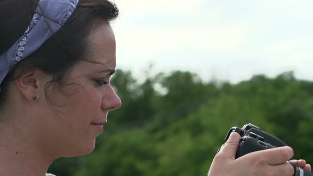 Female taking pictures in nature with a D-SLR camera.
